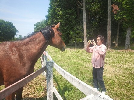 馬さんの写真を撮る永井さん