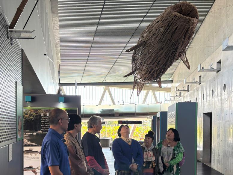 鮎の竹細工のオブジェを見上げる一行