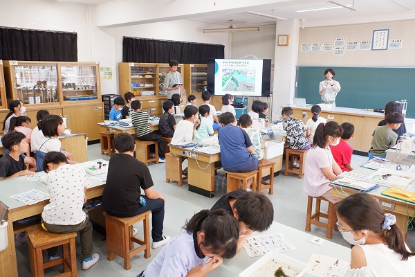 水生生物の観察方法についての説明を聞く様子